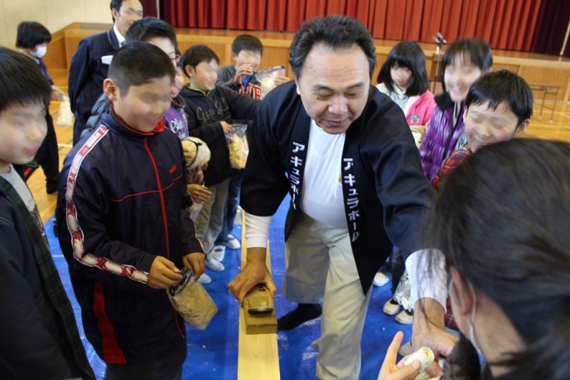 「ふれあい授業」で子供たちにカンナがけを教える宮沢社長＝愛知県丹羽郡の小学校で