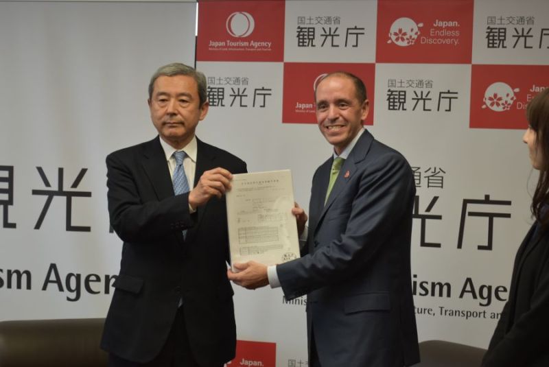 田村観光庁長官（左）に申請書類を手渡すエアビー責任者のレヘイン氏