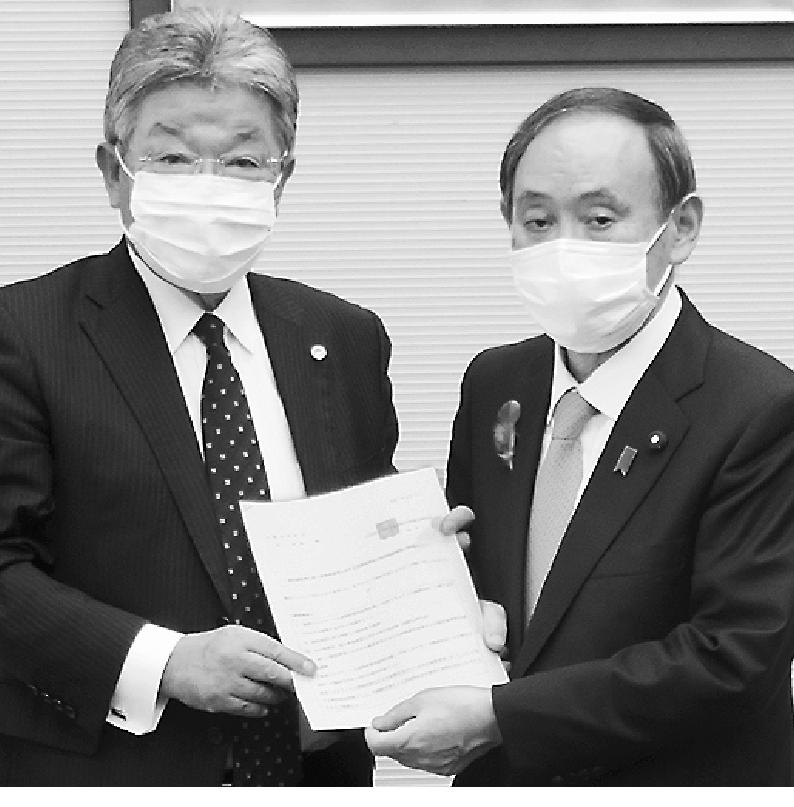坂本会長（左）が菅官房長官に要望書を提出